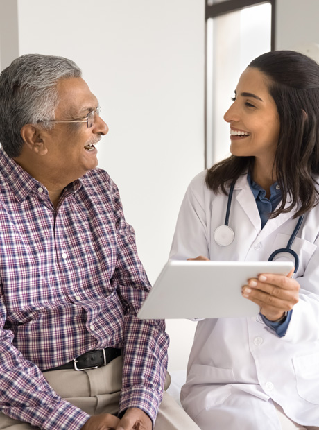 Un médico sostiene una tableta y analiza las opciones de atención médica con un paciente
