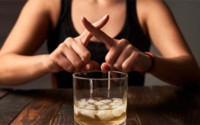 Person rejecting a glass of alcohol